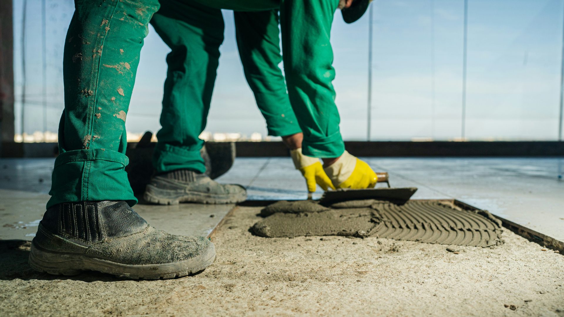 Eine Person verlegt Estrich für den Boden